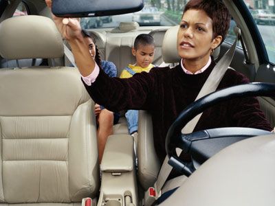 Woman driving with children in back seat. 