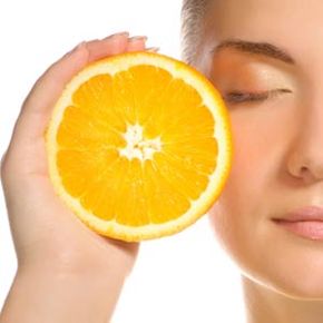 Woman with orange near face.