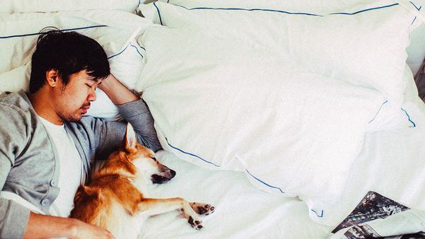 man sleeping with dog