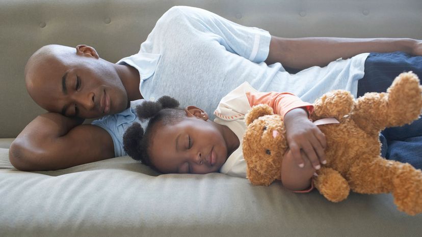 man, daughter and teddy sleeping on side