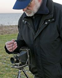 Man holding a cable release mechanism on an antique camera.&nbsp;