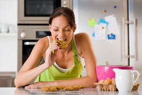 woman eating cookies in kitchen
