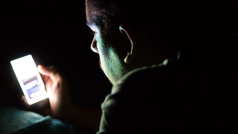 Man looking at phone in dark