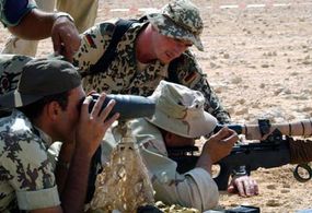 German and American snipers work together to sight a shot in desert training exercises.