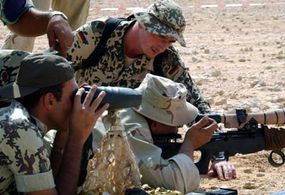  Des tireurs d'élite allemands et américains travaillent ensemble pour observer un tir lors d'exercices d'entraînement dans le désert.