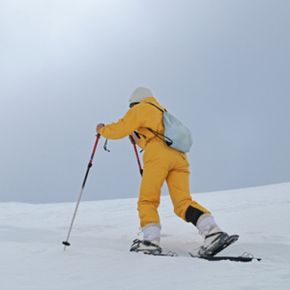 女人穿着雪鞋走”border=