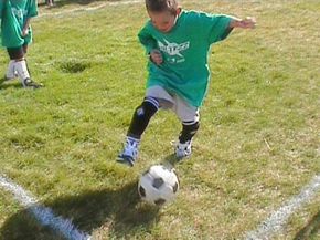 A young player dribbles the ball