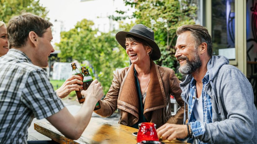A group of tourists take a break from exploring the city to sit down and have a beer together.