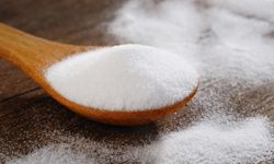 Baking soda on a wooden spoon.