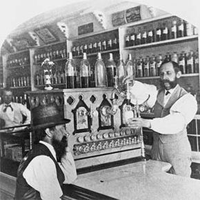 At this small-town soda fountain in the 1890s, a pharmacist whips up a fizzy concoction for a customer.