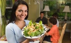 woman serving pasta to family