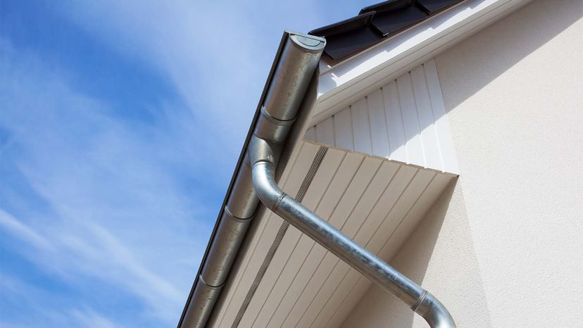 Eaves with gutters on a white house.