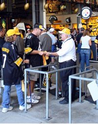 Football fans filing through a turnstile into the game