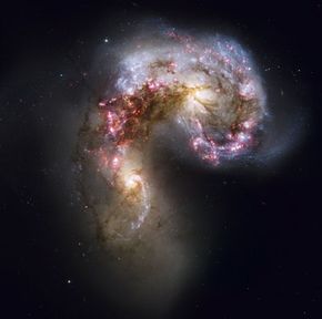Trailing streamers of gas and stars from the Antennae galaxies, which are currently undergoing a massive space collision.