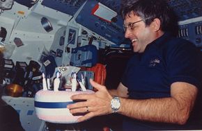 Sometimes space food isn't even food: Astronaut Daniel Brandenstein holds up inflatable cake in honor of his 47th birthday aboard the Space Shuttle Columbia.