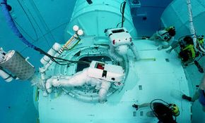 Astronauts training in water for a spacewalk to build the International Space Station