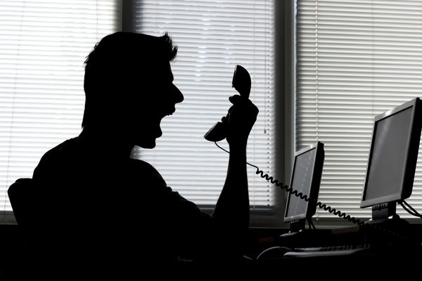 A man yelling into his phone at work.