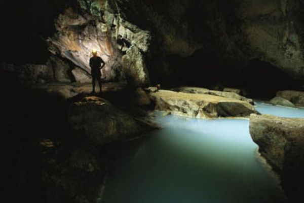 Person admiring nature in the dark by a rock object.