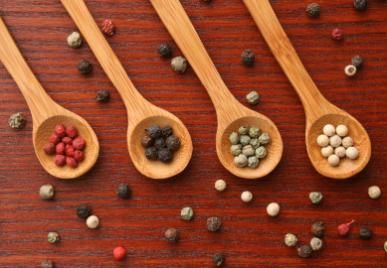 spoonfuls of red, black, green and white pepper