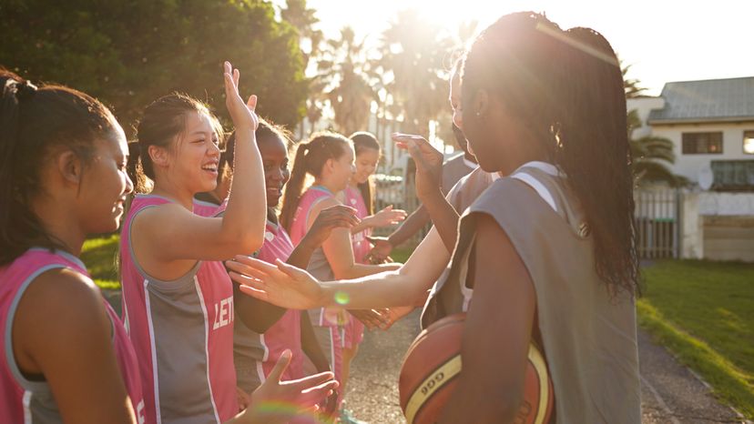 A group of female friends having high-five after basketball game