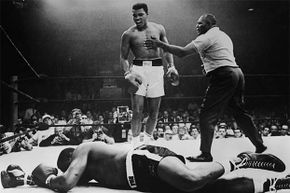 A gloating Muhammad Ali stands over Sonny Liston who was KO'd in the first round. Or did Liston take a dive?
