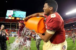 Jameis Winston of the Florida State Seminoles dumps the Gatorade bucket on head coach Jimbo Fisher after the Seminoles won the 2013 Orange Bowl.  The &quot;Gatorade dunk&quot;  sports tradition has been around since the 1980s.