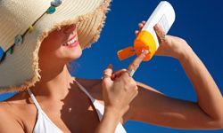 woman applies sunscreen