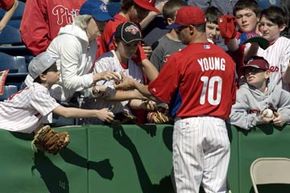Philadelphia Phillies' Michael Young signs autographs during a workout before a spring training game in Clearwater, Fla.