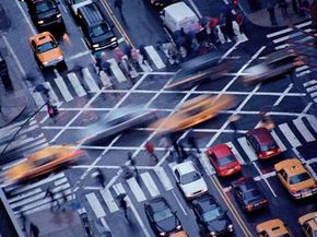 Traffic and pedestrians at a busy intersection. 