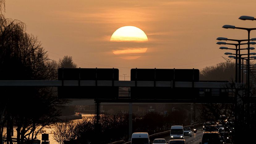 Vehicles move on at A-100 highway during sunset