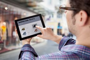 Man using tablet to shop while browing physical stores.