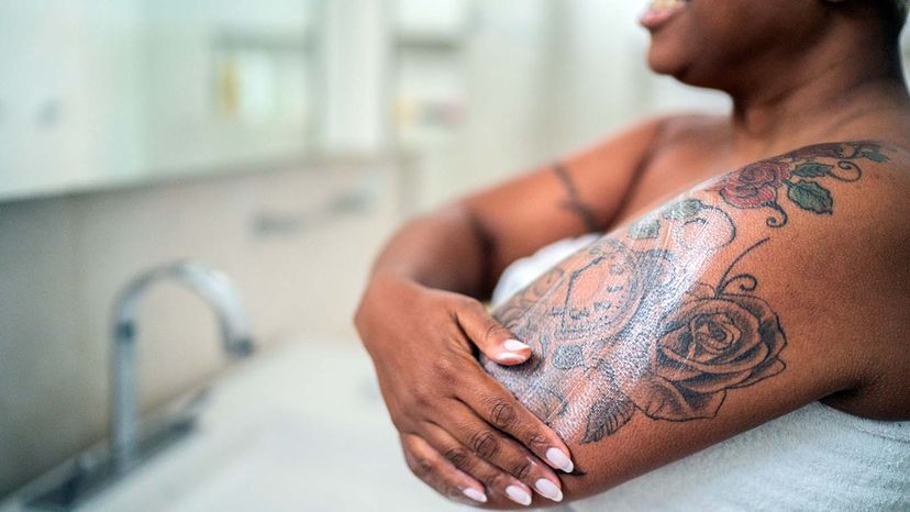 woman moisturizing tattoo