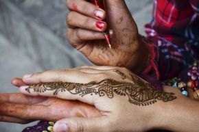 Someone gets a henna tattoo. 