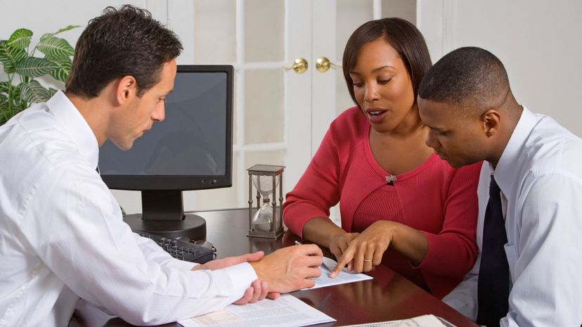 Businessman discussing paperwork with couple