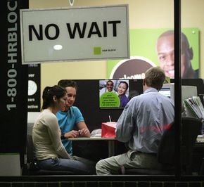 An H&R Block employee in Des Plaines, Ill., helps Senada Imsirovic (left) complete her tax return on April 13, 2006.”border=