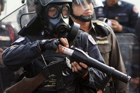 Riot police reload tear gas bullets outside Parliament House on Oct. 7, 2008, in Bangkok, Thailand.