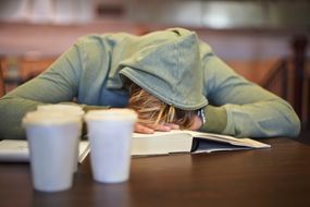 student asleep on books