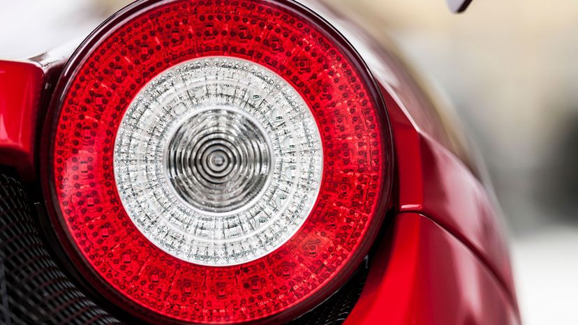 Round rear light of a red luxury sports car.