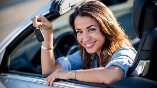 Woman holding car keys in hand in car