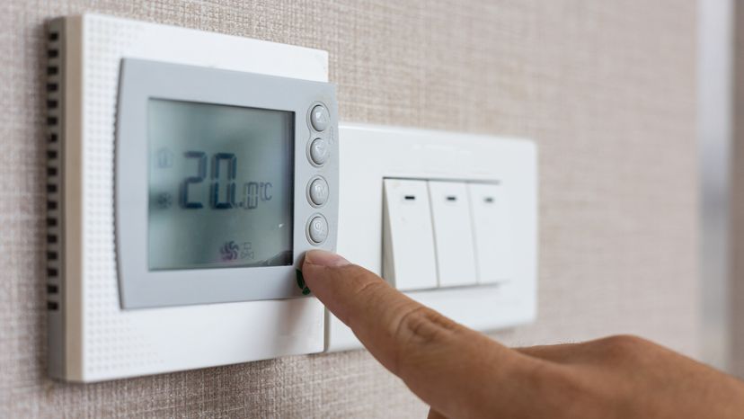 Close-up of hand operating the thermostat.