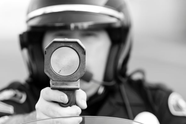 A police officer pointing a radar.