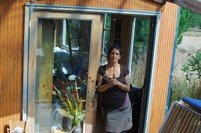 Lulu (no last name given) stands outside one of the two tiny houses she shares with her daughter. This one is used as a bedroom and office. The other has the kitchen and living area.