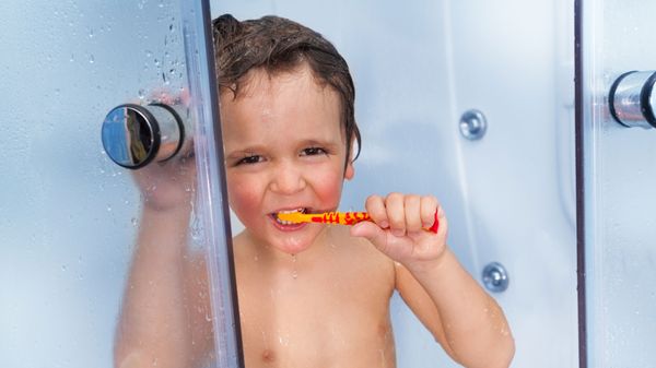 kid in shower with toothbrush