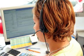 Call center employee with a headset and desktop computer.