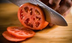 To rough dice, start by cutting your tomatoes into slices.