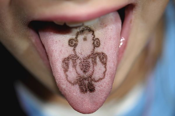 A child has a tongue tattoo. 