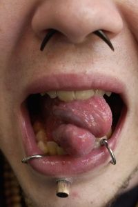 Person with split tongue and piercings
