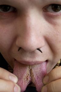 A 25-year-old tattoo artist shows how his split tongue has healed after he had the procedure done.