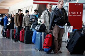 Passengers wait to check in at Logan International Airport in Boston.