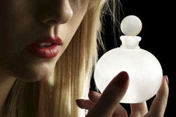 Woman staring at perfume bottle.
